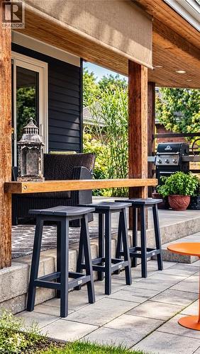 Covered patio featuring a wood-finish ceiling, wood posts, retractable shade, and paver flooring - 896 Eagle Drive, Burlington, ON 