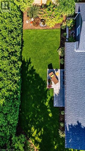 Expansive backyard featuring a manicured lawn, established garden beds, and a stone paver patio - 896 Eagle Drive, Burlington, ON 