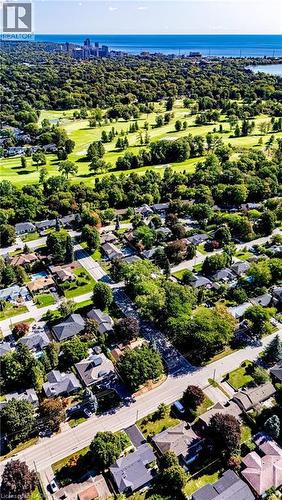 Aerial perspective showcasing a residential neighborhood, expansive green spaces, and a body of water with a city skyline in the distance - 896 Eagle Drive, Burlington, ON 