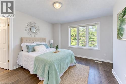 Light-filled room featuring wood-finish flooring, a neutral color palette, and a window with a green outdoor backdrop - 365 Woolwich Street, Waterloo, ON 