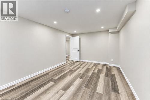 Recessed lighting, light gray wall finishes, wood-finish flooring, white trim, and a white interior door - 365 Woolwich Street, Waterloo, ON 