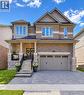 Brick and stone facade, double front doors, covered porch, paver driveway, and an attached two-car garage - 365 Woolwich Street, Waterloo, ON 
