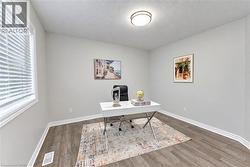 Neutral wall paint, wood-finish flooring, and a flush mount ceiling light - 