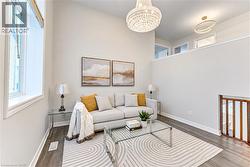 Vaulted ceiling, large window, wood-finish flooring, crystal chandelier, and upper wall opening with transom windows - 