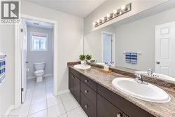 Double vanity with integrated sinks, a wide mirror, and a multi-bulb light fixture - 