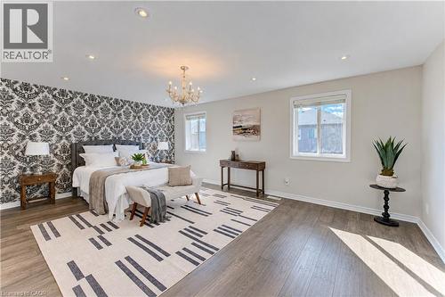 Recessed lighting, chandelier, two windows, wood-finish flooring, and a decorative accent wall - 365 Woolwich Street, Waterloo, ON 
