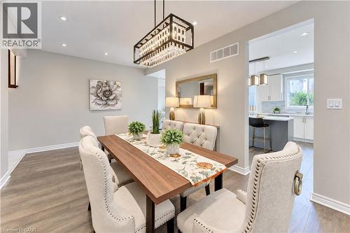 Wood-finish flooring with recessed lighting, a rectangular chandelier, and an open doorway to the kitchen - 365 Woolwich Street, Waterloo, ON 