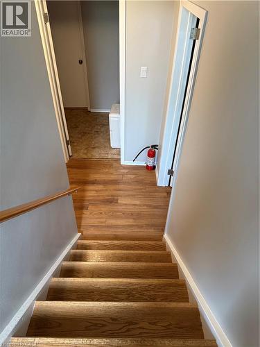 Wood-finish flooring with a matching wood handrail and light gray wall paint - 281 Toll Gate Boulevard, Waterloo, ON 