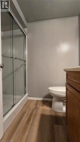 Walk-in shower with sliding glass doors, contemporary toilet, wood-finish flooring, and a neutral wall color - 281 Toll Gate Boulevard, Waterloo, ON 