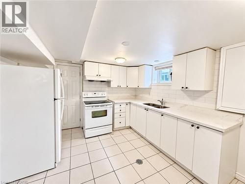 Kitchen featuring white cabinetry, white subway tile backsplash, white countertops, and white appliances - 84 Weber Street S, Waterloo, ON 