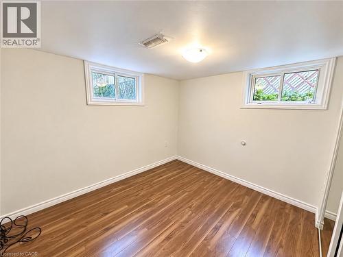 Wood-finish flooring, white trim, two windows, and a ceiling-mounted light fixture - 84 Weber Street S, Waterloo, ON 