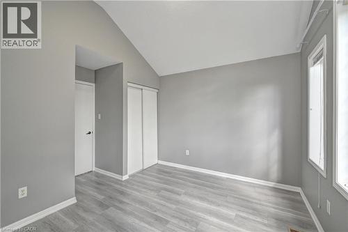 Vaulted ceiling, light wood-finish flooring, white trim, sliding closet doors, and multiple windows - 103 Blackbird Circle, Cambridge, ON 