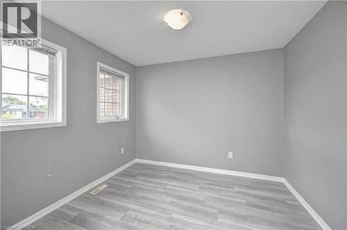 Light gray walls complemented by wood-finish flooring - 103 Blackbird Circle, Cambridge, ON 