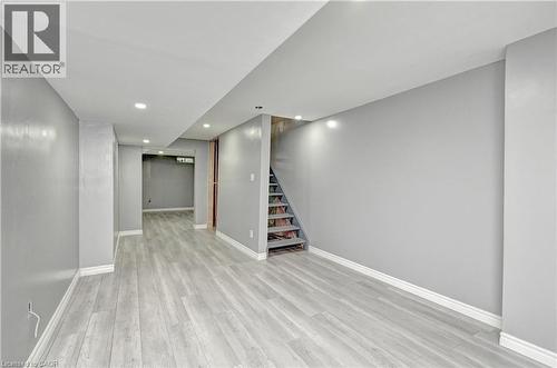 Recessed lighting, wood-finish flooring, light gray wall color, white trim, exposed wooden staircase - 103 Blackbird Circle, Cambridge, ON 