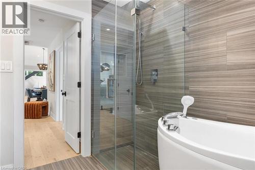 Glass-enclosed shower with a rainfall showerhead, alongside a freestanding soaking tub - 293 North Shore Boulevard E, Burlington, ON 