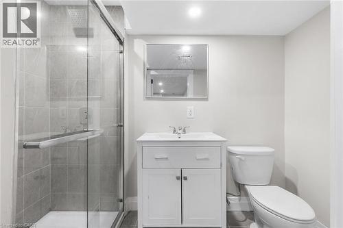 Glass-enclosed shower with gray tiled walls, white vanity with integrated sink, chrome faucet, and recessed lighting - 293 North Shore Boulevard E, Burlington, ON 