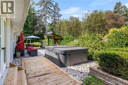 Hardscaping featuring a wood deck, a stone patio, and a hot tub - 293 North Shore Boulevard E, Burlington, ON 
