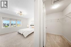 Bedroom featuring light carpet, a textured ceiling, and a chandelier - 