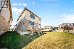 Rear view of property with brick siding, a lawn, and a residential view - 