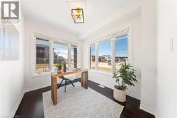Office space featuring dark wood-style flooring and plenty of natural light - 