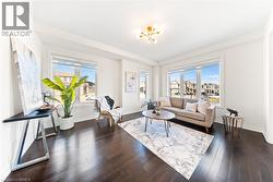 Living room with healthy amount of natural light, dark wood finished floors, and a chandelier - 