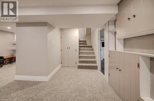 Plush carpeting throughout, built-in cabinetry with shelving, carpeted staircase, and recessed lighting - 37 Margaret Avenue N, Waterloo, ON 