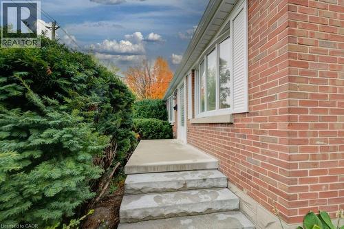 Red brick exterior with white window shutters and concrete steps - 37 Margaret Avenue N, Waterloo, ON 