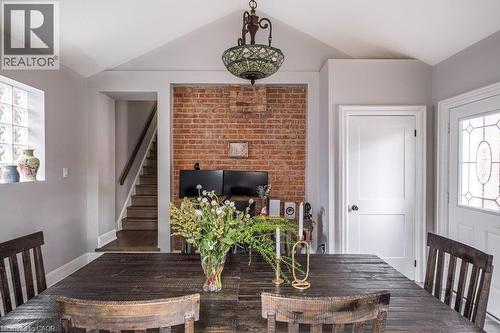 Bright dining room/home office combination featuring a cozy gas fireplace, walkout to the large deck and beautifully landscaped backyard, with private parking for 2–3 cars. - 132 Herkimer Street, Hamilton, ON 