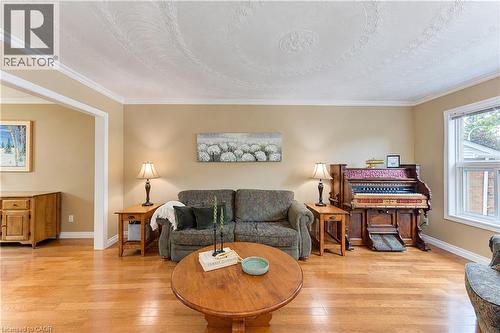 Hardwood flooring, crown molding, coved ceiling with decorative medallion, light-toned wall paint, and a window with white trim - 104 Deerwood Crescent, Kitchener, ON 
