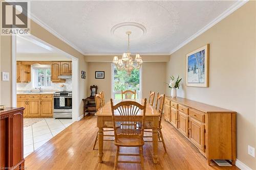 Hardwood flooring, crown molding, coved ceiling with medallion, chandelier, and a wide cased opening to the kitchen - 104 Deerwood Crescent, Kitchener, ON 
