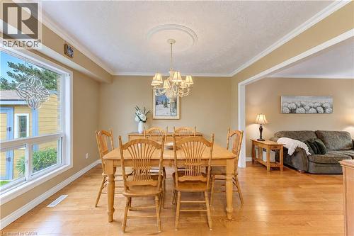 Hardwood flooring, crown molding, white trim, recessed archway, and a decorative ceiling medallion with a chandelier - 104 Deerwood Crescent, Kitchener, ON 