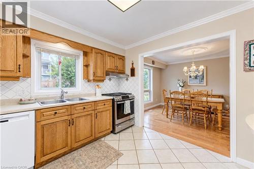 Kitchen featuring wood cabinetry, stainless steel range, and tile flooring - 104 Deerwood Crescent, Kitchener, ON 