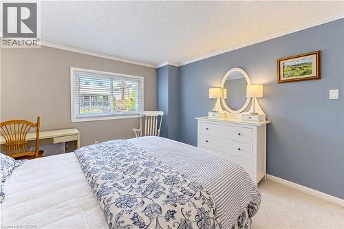 Window with blinds, wall-to-wall carpeting, crown molding, built-in dresser with mirror, and recessed lighting - 104 Deerwood Crescent, Kitchener, ON 