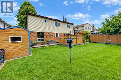 Expansive lawn with a wooden shed, a privacy fence, and a patio area with a wooden railing - 104 Deerwood Crescent, Kitchener, ON 
