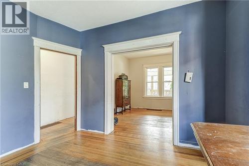 Hardwood flooring throughout, multiple doorways with classic trim work, and a window offering natural light - 11 Elm Street, Hamilton, ON 