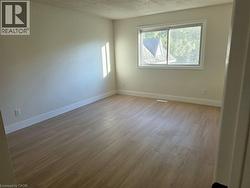 Light-toned walls, wood-finish flooring, and a large window - 