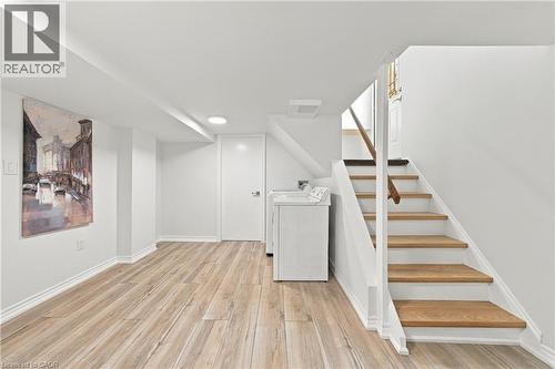 Wood-finish flooring, white painted walls, recessed lighting, and a straight staircase with a wooden handrail - 662 Dynes Road, Burlington, ON 