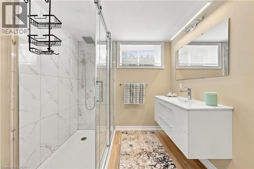 Shower with white large-format tiled walls and glass sliding door - 662 Dynes Road, Burlington, ON 