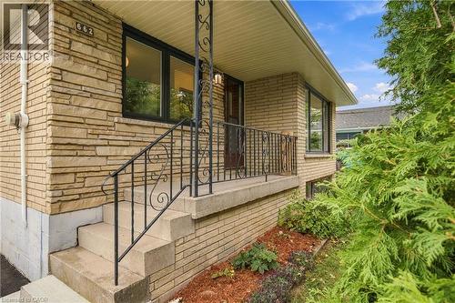 Stacked stone and brick-finish exterior with dark-framed windows - 662 Dynes Road, Burlington, ON 