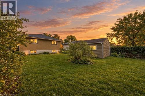Expansive green lawn, mature trees, and a detached shed with horizontal siding - 662 Dynes Road, Burlington, ON 