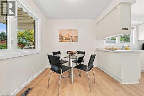 Bright dining area featuring a large casement window and wood-finish flooring - 662 Dynes Road, Burlington, ON 