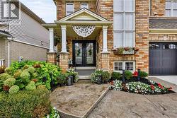 Brick exterior with a covered entryway, decorative front door, and an attached garage - 