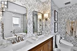 Dual vanity with integrated sinks and bronze-finish faucets, set beneath a large framed mirror - 