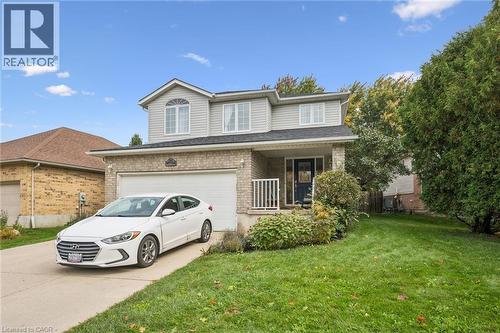 Two-story residence featuring brick and siding exterior, an integrated garage, a front porch with white railing, and a paved driveway - 233 Dearborn Boulevard, Waterloo, ON 