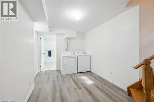 Laundry area featuring wood-finish flooring, white walls, and bright overhead lighting - 233 Dearborn Boulevard Unit# Lower, Waterloo, ON 