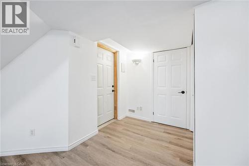 Wood-finish flooring, white paneled doors, and contemporary wall sconce lighting - 233 Dearborn Boulevard, Waterloo, ON 