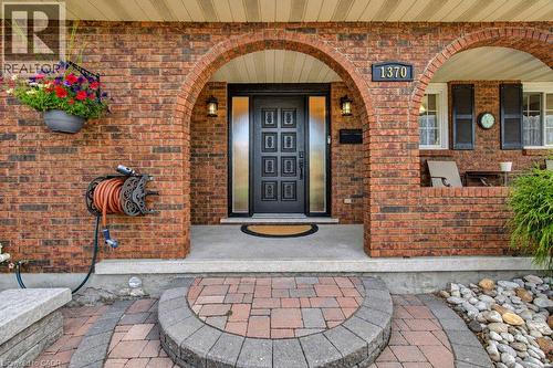 Brick exterior with arched entryways, a decorative front door with side lites, and a paver pathway - 1370 Thorman Place, Cambridge, ON 
