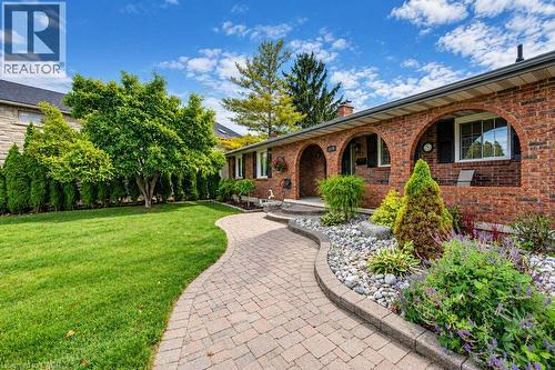 Brick exterior with arched entryways and contrasting black shutters - 1370 Thorman Place, Cambridge, ON 