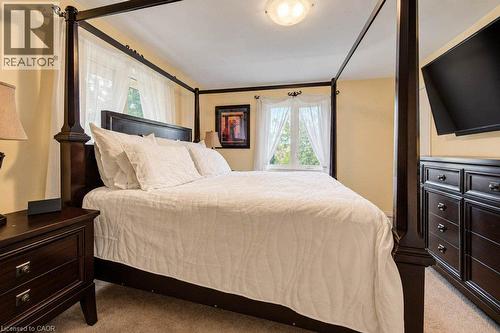 Carpeted room with a ceiling-mounted light fixture, multiple windows, and light-toned wall finishes - 1370 Thorman Place, Cambridge, ON 