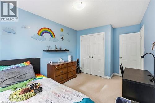 Carpeted room featuring a ceiling-mounted light fixture, painted walls, and white paneled doors - 1076 Ryckman Common, Burlington, ON 